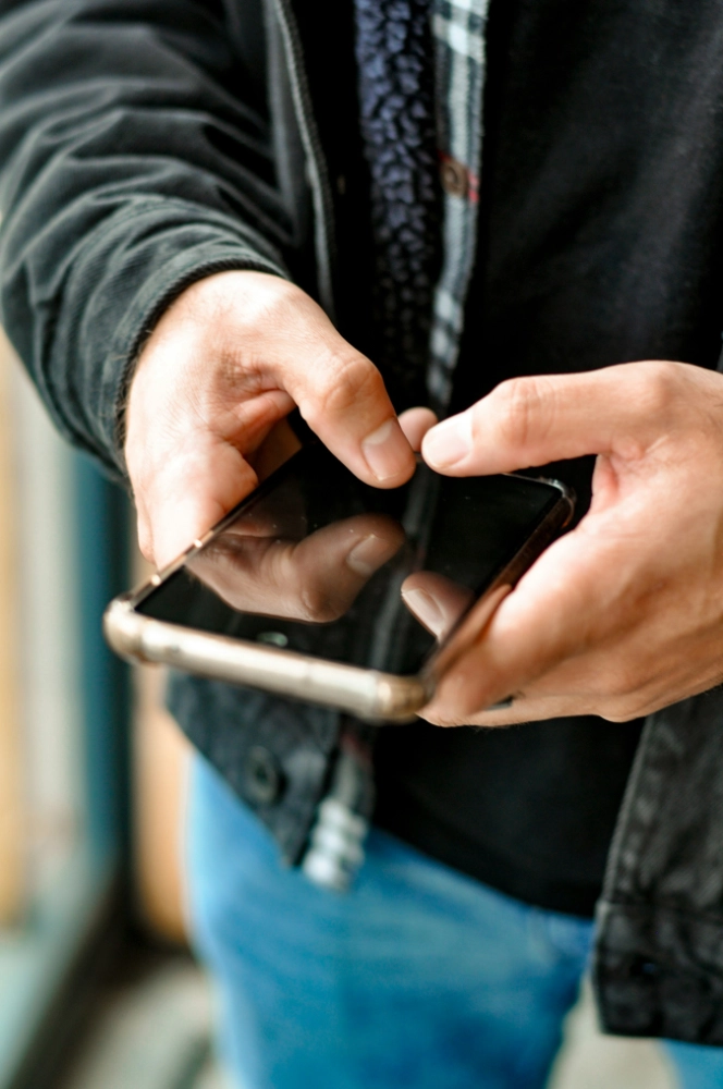Eine Person, die ein Mobiltelefon hält.